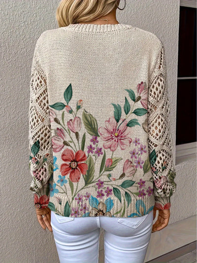 Beige sweater with floral embroidery worn by a person against a neutral background